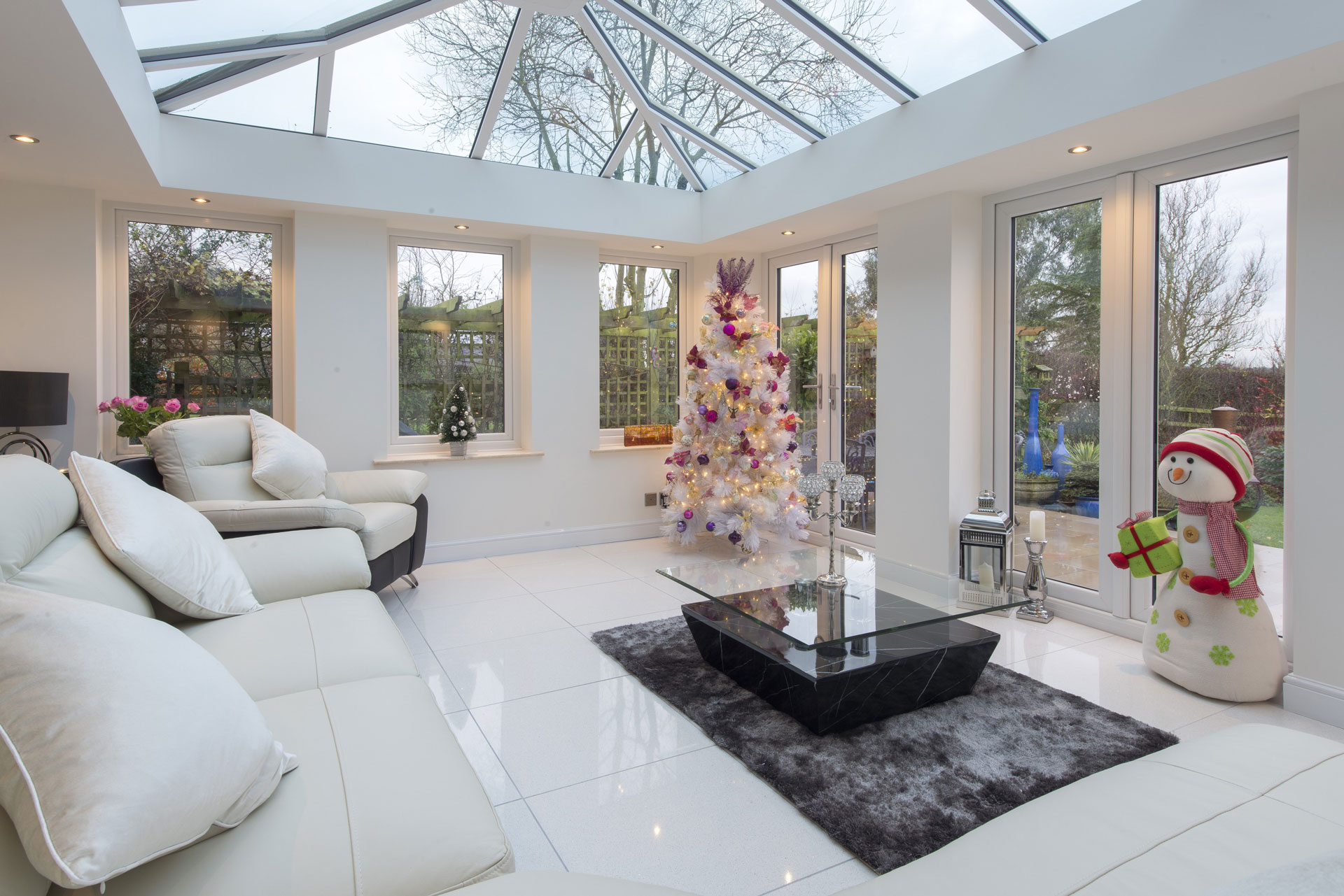Glass extension with white sofa and festive decorations